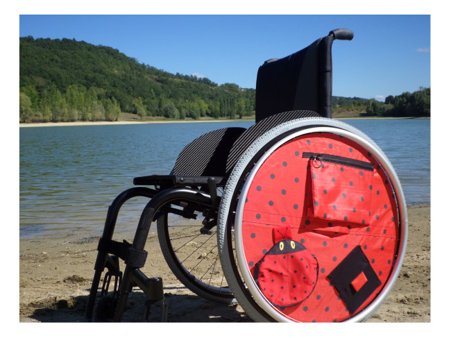 Accessoire pour fauteuil roulant : Enjolieroue avec poche 1 plate zippée - 1 poche maille - 1 poche amovible + 1 enjolieroue assortie